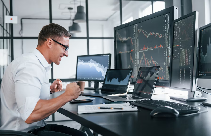How do prop firm work - trader monitoring multiple trading screens
